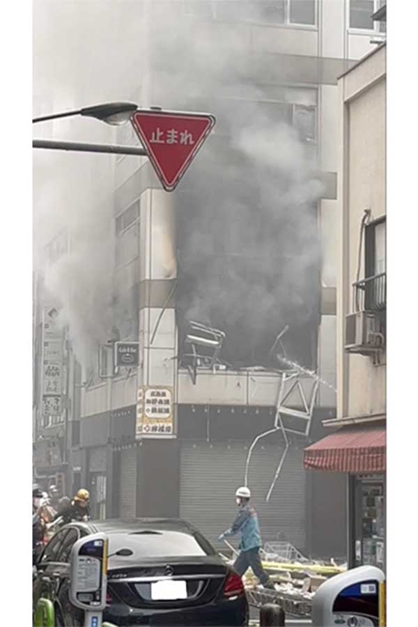 ビルの二階から煙が上がり、消防の消火水が煙に向かって放水されているのが確認できる【写真：“Show”大谷泰顕】