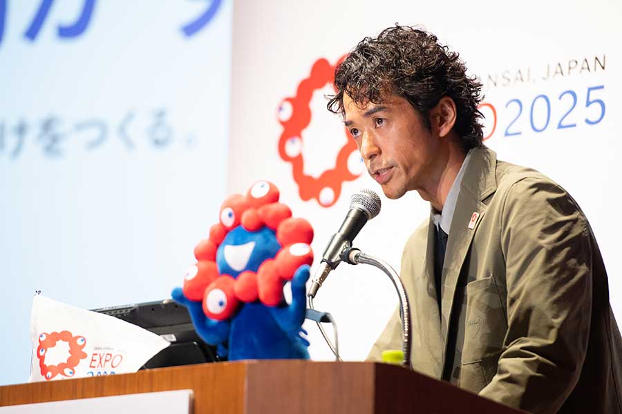 3月14日、大阪・関西万博の説明会で熱弁する小橋賢児氏。左には公式キャラクター・ミャクミャク