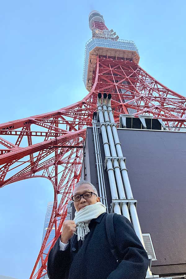 東京タワーをバックにポーズを取る“徳分スタイル”の石井館長【写真：本人提供】