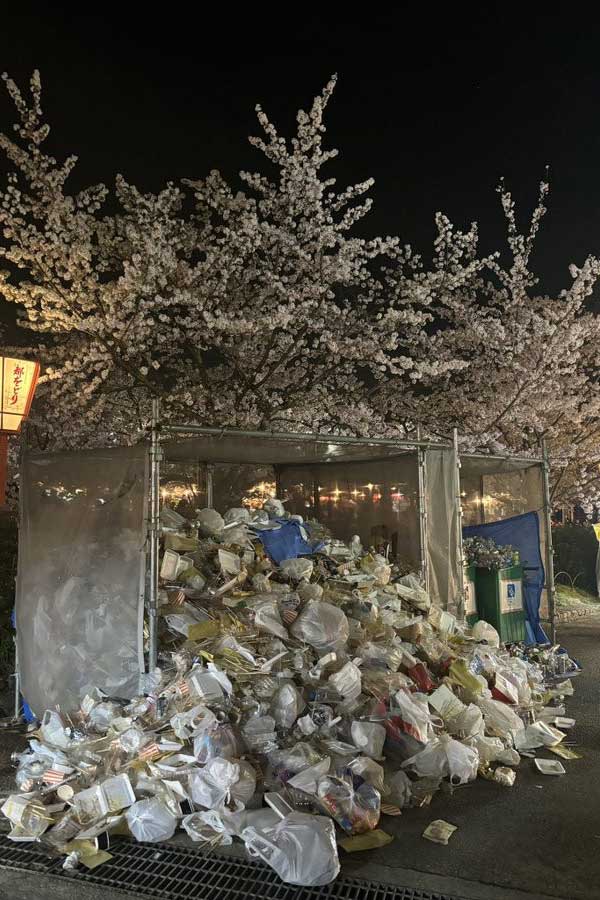 夜桜の下にうず高く積み上げられたゴミの山【写真：投稿者提供】