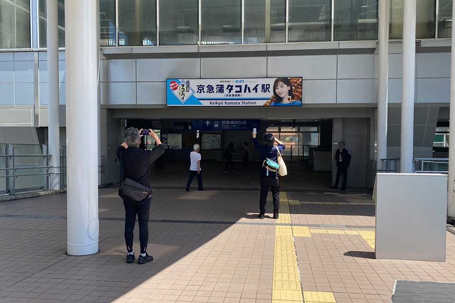 5月29日時点で京急蒲田駅に設置されていた特設看板、写真を撮影する通行客の姿も数多く見られた【写真：ENCOUNT編集部】