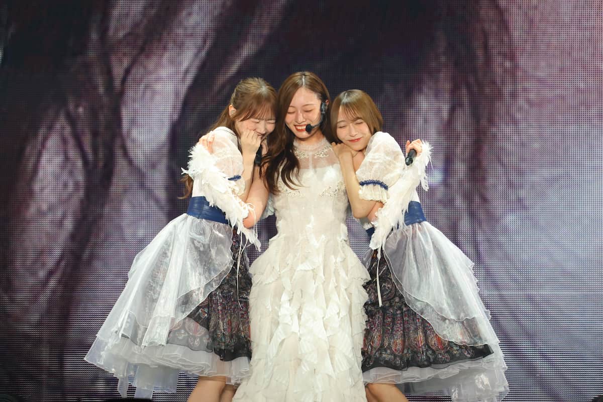 メンバーと肩を寄せ合う場面も【写真：(C)乃木坂46LLC】